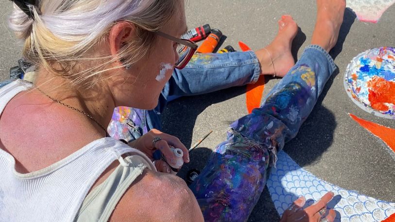 Sally Martin is covered in paint as she creates some fish at Echo Farms Park. (Spectrum News 1/Natalie Mooney)